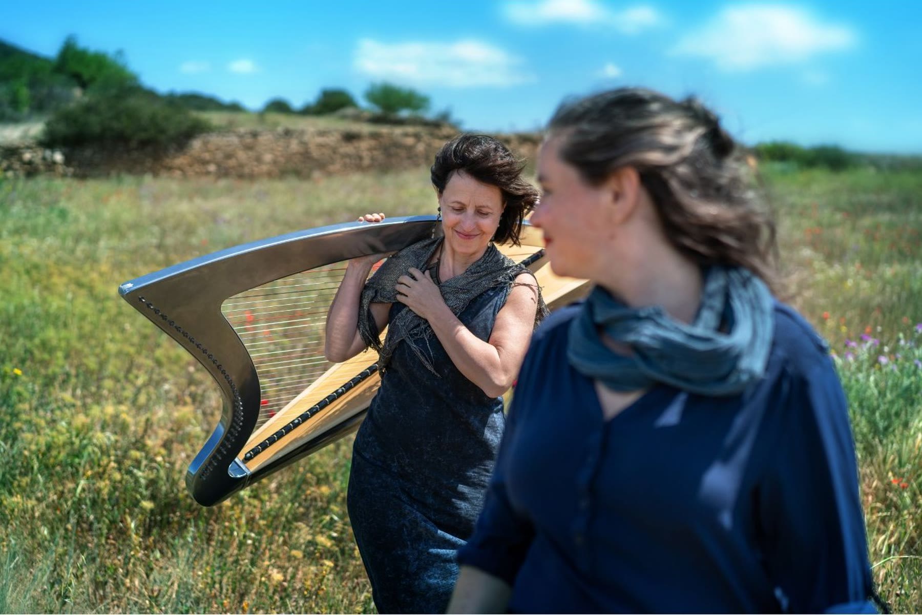 Eglantine Jouve et Elisa Vellia, complices, la harpe entre elles, dans l'herbe