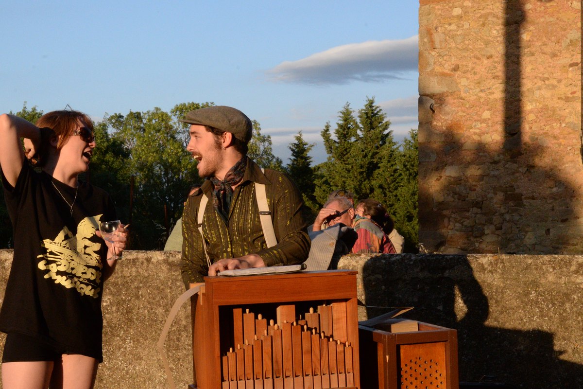 Aymé Médeville à la manivelle de son orgue de Barbarie, devant les tablées