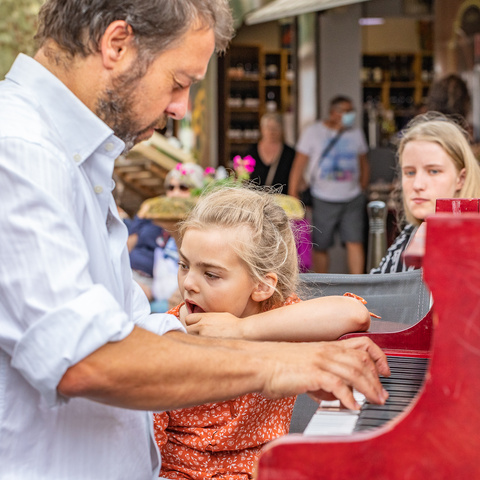 Jérôme Médeville faisant essayer le clavier à des enfants dans la rue