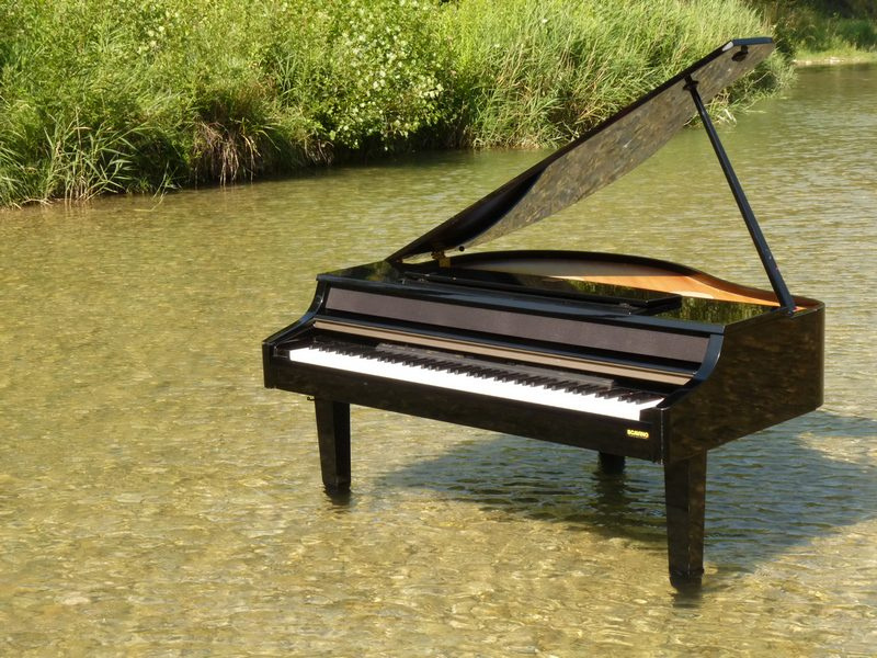 Le piano noir posé au milieu d'une rivière