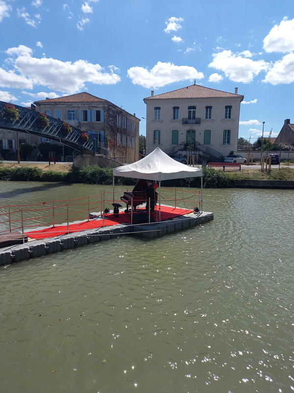 Le piano installé sur un ponton flottant, sur un canal