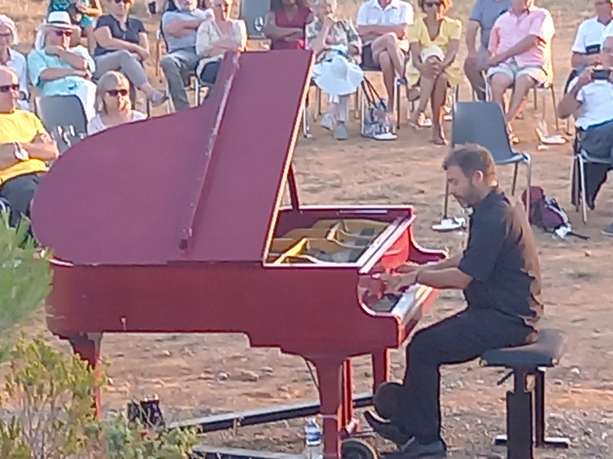 Le piano rouge et le public installé tout autour, en plein air