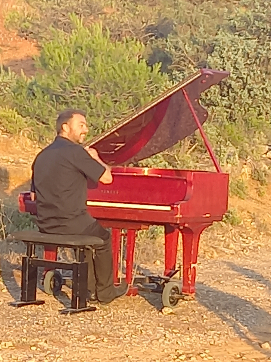 Le piano rouge, quart de queue Yamaha, posé sur un chemin de terre
