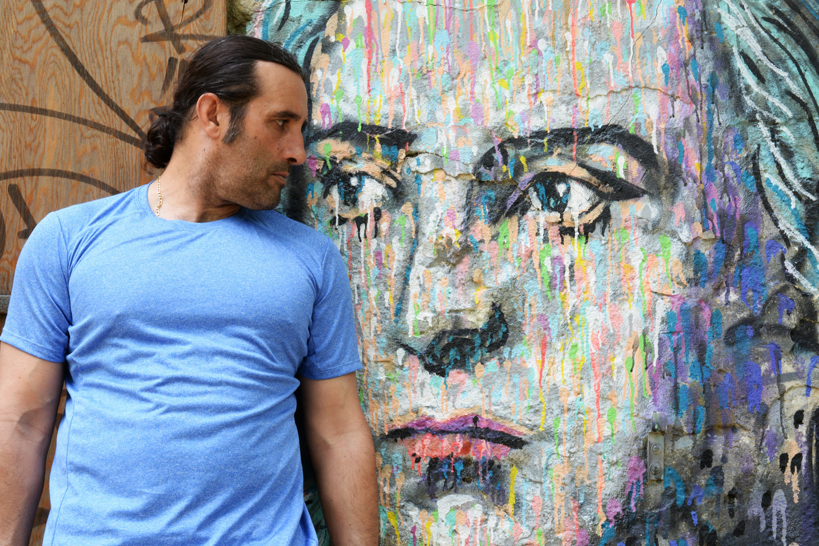 Grégory Nardella devant une fresque de regards